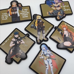 Op de afbeelding: Een verzameling rechthoekige patches met anime-achtige personages met wapens. De patches hebben een bruinachtige achtergrond en zwarte randen. Tekst op de patches bevat zinnen als "My Rifle My Waifu" en "They Blow Up So Fast."