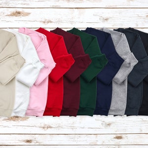 a bunch of sweaters are lined up on a wooden surface