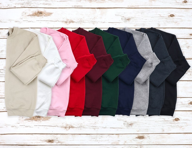 a bunch of sweaters are lined up on a wooden surface