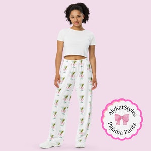 May include: White pajama pants with a repeating pattern of martini glasses with pink bows. The text "AlyKatStyles Pajama Pants" is on a pink circle with a pink bow.