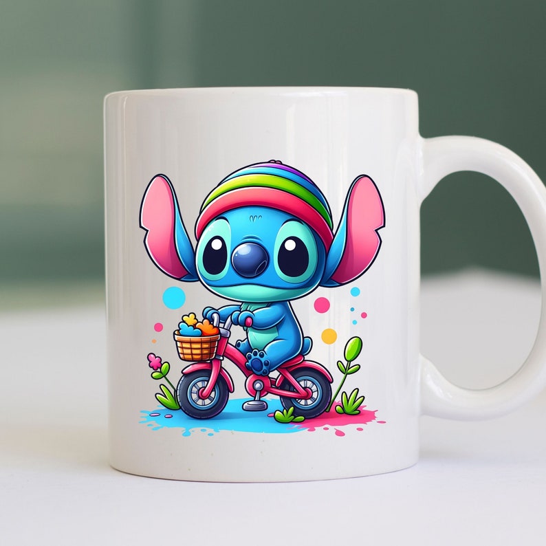 May include: White ceramic mug with a blue and pink cartoon character riding a pink bicycle with a basket of flowers. The character is wearing a rainbow hat.