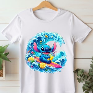 May include: A white t-shirt with a blue cartoon character surfing on a wave. The character is holding a yellow drink and there are lemons and flowers around the wave.