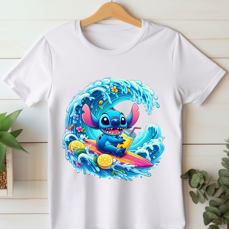 May include: A white t-shirt with a blue cartoon character surfing on a wave. The character is holding a yellow drink and there are lemons and flowers around the wave.