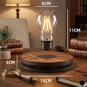 May include: A decorative light bulb, 11cm tall and 6cm wide, with a clear glass bulb and a black base, sits above a wooden base, 15cm wide and 3cm tall. The base has a geometric design. A magnifying glass and books are also visible.