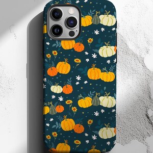May include: A navy blue phone case featuring a repeating pattern of pumpkins in shades of orange, yellow, and white, along with small white flowers and yellow sunflowers. The case is designed to fit a smartphone.