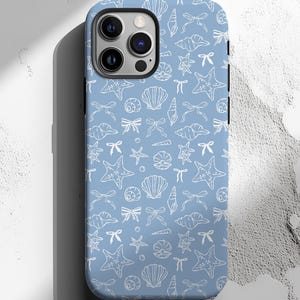May include: A light blue phone case featuring a repeating pattern of white seashells, starfish, and bows. The case has a black border and a camera cutout. The design is a nautical theme.