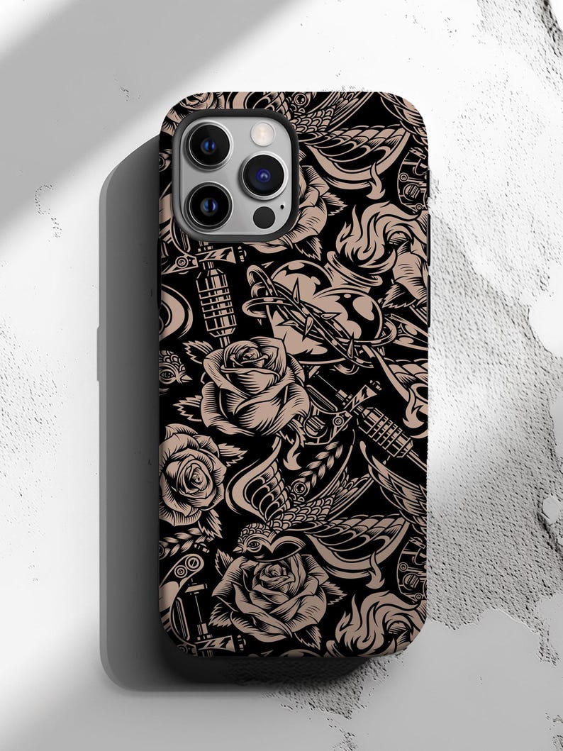 May include: Black iPhone case with a repeating tattoo-style design. The pattern features roses, hearts, daggers, and other classic tattoo motifs in tan and black. The case has a glossy finish and a camera bump.