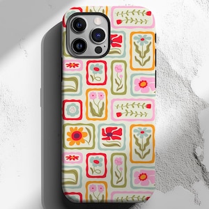 May include: A phone case with a colorful floral pattern. The design features rectangular frames with various flowers in shades of pink, orange, blue, and green on a cream background. The case has a glossy finish and a camera cutout.