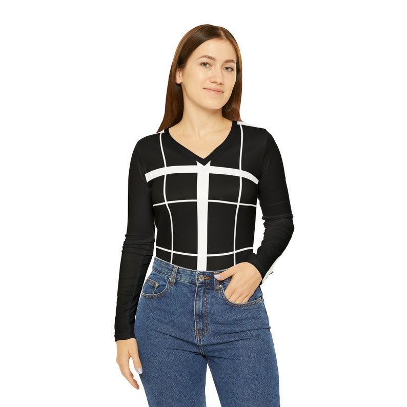 Puede incluir: Una camisa negra de manga larga con un patr&oacute;n de cuadr&iacute;cula blanca. La camisa tiene cuello en V y se lleva con jeans azules.