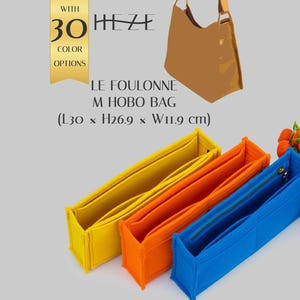 Può includere: Tre organizer per borsa rettangolari in feltro giallo, arancione e blu. Il testo recita: WITH 30 COLOR OPTIONS, HEZE, LE FOULONNE M HOBO BAG, (L30 x H26.9 x W11.9 cm). L'organizer blu presenta una chiusura a zip metallica sul bordo.