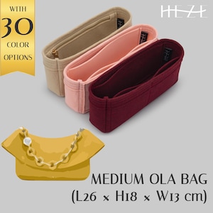 May include: An image showcases three felt bag organizers in beige, pink, and burgundy, with a yellow purse in the foreground. The text indicates 30 color options and the dimensions of the Medium OLA Bag: 26 cm L x 18 cm H x 13 cm W.