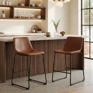 May include: Two bar stools with tan leather seats and black metal frames. The stools feature a curved backrest and a sled-style base. They are positioned in front of a kitchen island with a white marble countertop and a slatted wood base.