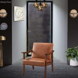 May include: A brown leather armchair with wooden armrests and legs. The chair is positioned in a room with a dark gray door and a modern light fixture. The wall art features a black abstract design.