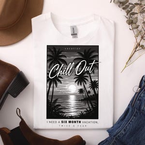 Könnte beinhalten: Weißes T-Shirt mit einem Schwarz-Weiß-Grafik einer tropischen Strandszene, Palmen und dem Schriftzug "Chill Out". Der Text "I need a six month vacation, twice a year" ist ebenfalls auf dem Shirt aufgedruckt.