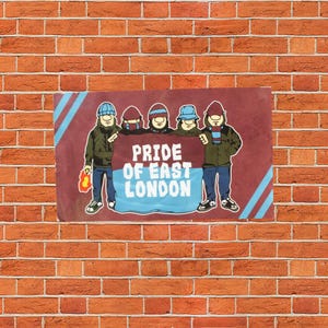 Puede incluir: Una pancarta rectangular con el texto "PRIDE OF EAST LONDON" en blanco y azul claro. La pancarta presenta figuras de dibujos animados con sombreros y chaquetas. El fondo es una pared de ladrillos rojos.