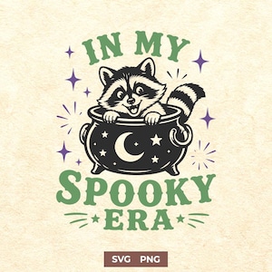 May include: A graphic illustration featuring a raccoon sitting inside a black cauldron decorated with a white crescent moon and stars. The text "IN MY SPOOKY ERA" is written in green above and below the cauldron, surrounded by purple stars.