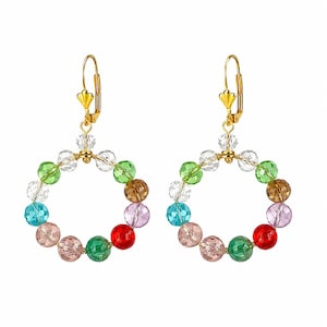 May include: A pair of dangle earrings featuring circular hoops made from multi-colored faceted crystal beads in shades of red, green, blue, pink, and clear. The beads are connected by gold-toned wire and suspended from gold-toned leverback hooks.