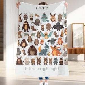 May include: A white blanket with a colorful illustration of various cartoon monsters and the text "future cryptologist". The blanket also has the word "name" at the top.