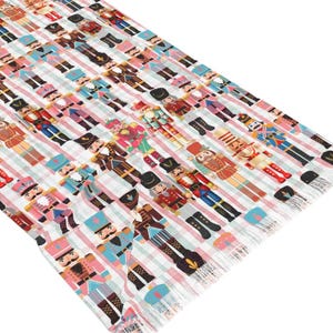 May include: A rectangular table runner featuring a repeating pattern of nutcracker figures in various uniforms of red, blue, pink, and brown. The figures are arranged in vertical rows against a background of light pink and white vertical stripes.