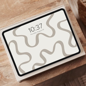 May include: A white tablet with a black border displaying a digital clock with the time 10:37 and the date Thursday, August 29. The background of the screen is a light beige with a pattern of wavy lines.