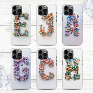 May include: Six white iPhone cases with floral designs and letters. Each case features a different letter of the alphabet, from A to G, made of colorful flowers and butterflies.