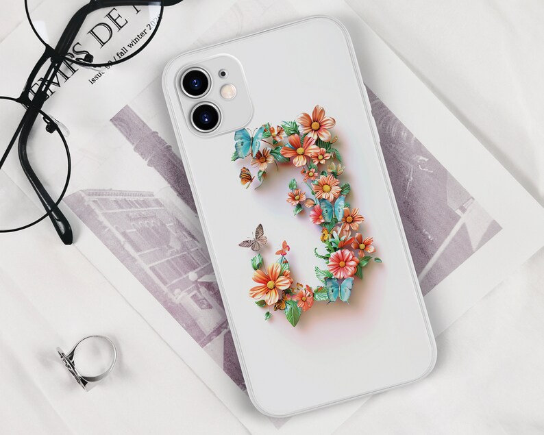 May include: White phone case with a floral design featuring a large letter 'C' made of pink, orange, and yellow flowers with blue butterflies.