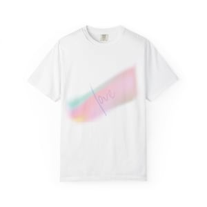 Puede incluir: Una camiseta blanca de manga corta con un gráfico diagonal difuminado en tonos pastel rosa, azul y amarillo. La palabra "love" está escrita en una fina letra cursiva sobre el centro del diseño abstracto, colorido y vaporoso.