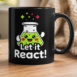May include: Black ceramic mug featuring a cartoon beaker with a smiling face and the words "Let it React!". The beaker is green with white arms and a white top. Green and red star shapes are above the beaker.