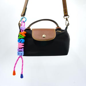 Personalisierte geflochtene Regenbogen Name Charm | Personalisierter Taschenanhänger | Rucksack-Charm | Kinderrucksack-Zubehör | Windeltasche | Trageanhänger Anhänger.