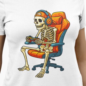 Cartoon skeleton wearing a backwards cap and headphones, sitting in an orange gaming chair while holding a game controller. High-contrast, playful gamer artwork for a unisex T-shirt in adult, youth, and toddler sizes—great for Halloween, streaming, LAN parties, and gifts for console fans.