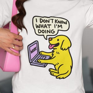 May include: White t-shirt featuring a cartoon dog working on a laptop with the word "WORK" on the screen. The dog has a speech bubble that says "I DON'T KNOW WHAT I'M DOING".