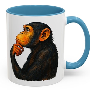 May include: White ceramic coffee mug with a blue interior and handle. The mug features a detailed illustration of a chimpanzee in a thinking pose. The chimpanzee has orange skin and black fur.