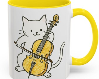 May include: White ceramic mug with a yellow rim and handle. The mug features a cartoon illustration of a white cat playing a cello.