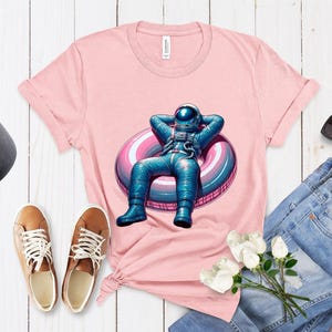 Space-Themed Unisex T-Shirt, Astronaut Lounging Shirt Design, Galaxy Inflatable Ring Tee Top, Unique Cosmic Fashion, Gift for Her/Him