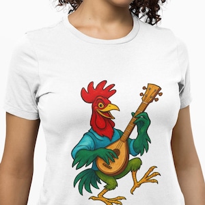 May include: White t-shirt featuring a cartoon rooster playing a mandolin. The rooster has a red comb, yellow beak, and is wearing a blue shirt and green gloves. The mandolin is brown with a light wood finish. The rooster's legs are green and yellow.
