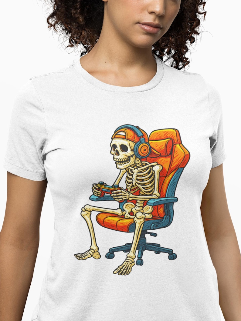 Cartoon skeleton wearing a backwards cap and headphones, sitting in an orange gaming chair while holding a game controller. High-contrast, playful gamer artwork for a unisex T-shirt in adult, youth, and toddler sizes—great for Halloween, streaming, LAN parties, and gifts for console fans.