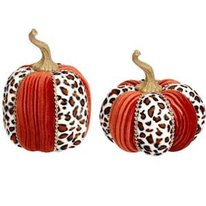May include: Two decorative pumpkins featuring alternating panels of orange velvet and white fabric with a brown and black leopard print. Each pumpkin is topped with a textured gold stem and accented with thin, sparkling rhinestone trim.