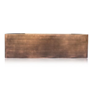 K&ouml;nnte beinhalten: Ein rechteckiger Pflanzkasten aus Metall in Bronzefarbe. Der Pflanzkasten hat eine geb&uuml;rstete Oberfl&auml;che, die ihm ein strukturiertes Aussehen verleiht. Die Box ist mit einer einfachen, modernen &Auml;sthetik gestaltet, die sich f&uuml;r den Innen- und Au&szlig;enbereich eignet.