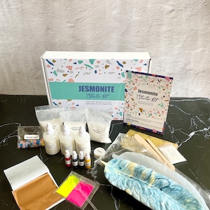 May include: A Jesmonite Starter Kit with a variety of supplies, including white powder, liquid resin, pigments, gold leaf, and a silicone mold shaped like a feather. The kit is packaged in a box with a terrazzo pattern.