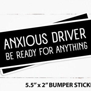Op de afbeelding: Zwart-witte bumper sticker met de tekst "Anxious Driver Be Ready For Anything". De sticker is 5,5 inch bij 2 inch.