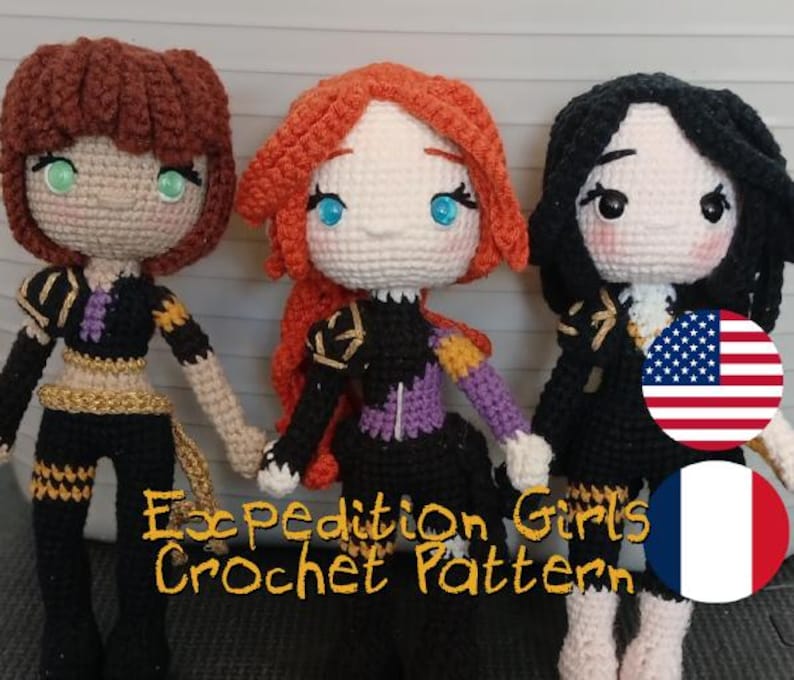 May include: Three handmade crochet dolls with different hair colors: brown, red, and black. Each doll wears a black outfit with gold and purple accents. The dolls have detailed facial features and are standing together. The text "Expedition Girls Crochet Pattern" is visible.