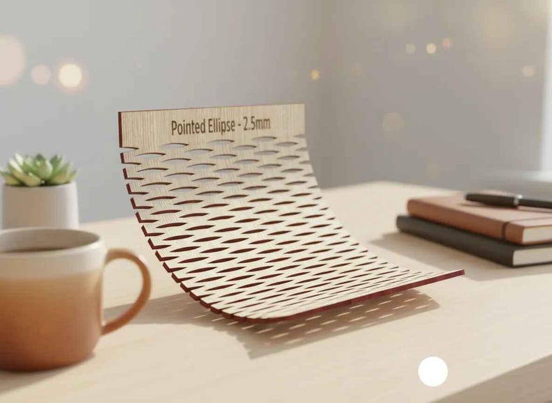 Puede incluir: Una pieza decorativa de madera curvada con un dise&ntilde;o de celos&iacute;a y el texto "Pointed Ellipse - 2.5mm". La pieza es de color marr&oacute;n claro con bordes rojos y se encuentra sobre una superficie clara. Una taza de caf&eacute; y una planta suculenta est&aacute;n en el fondo.