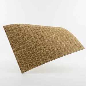 Puede incluir: Un objeto rectangular curvado con un patr&oacute;n geom&eacute;trico repetitivo. El patr&oacute;n consiste en dise&ntilde;os cuadrados entrelazados en tonos marrones. El objeto parece estar hecho de un material texturizado, posiblemente madera o una fibra natural similar.