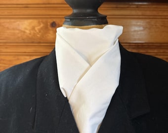May include: A black blazer with a white collared shirt, displayed on a wooden mannequin. The blazer has a classic design with lapels and a tailored fit. The white shirt is neatly folded and tucked into the blazer.