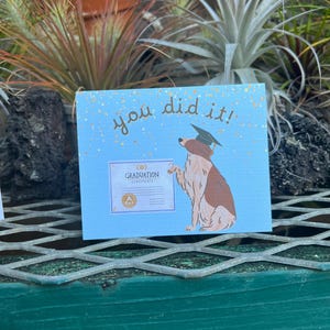 Tarjeta de celebración de graduación / Ceremonia de escuela secundaria, universidad y universidad / Lindo cachorro con birrete de graduación, ramo de flores de confeti especial