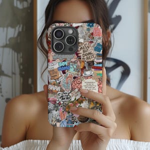 Puede incluir: Una funda de teléfono con un collage de pegatinas, incluyendo textos como "Boy Mama", "Tired as a Mother" y "Bit of a Mess But Doing My Best". El diseño presenta motivos florales, tazas de café y una ilustración de corazón anatómico.