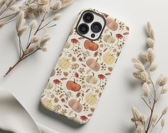 May include: A white iPhone case with a pattern of orange, yellow, and white pumpkins, leaves, and flowers. The case has a black camera bump with three lenses.