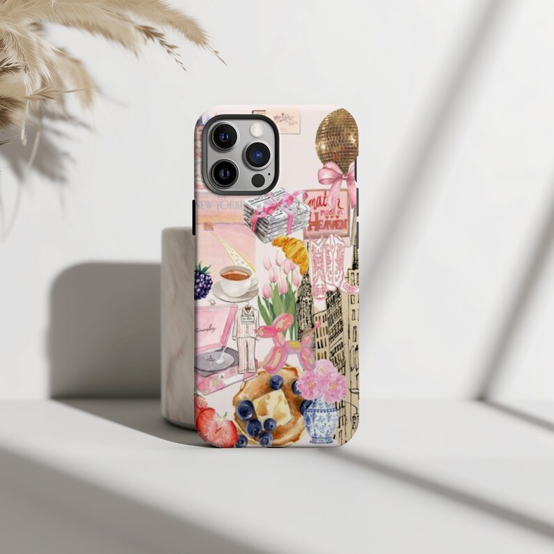 Op de afbeelding: Een roze iPhone-hoesje met een collage van afbeeldingen, waaronder een platenspeler, een kopje koffie, een bos roze tulpen, een roze ballon, een gebouw en de tekst "That's what I call heaven".