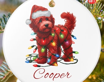 May include: A white, round Christmas ornament featuring a red dog wearing a Santa hat and wrapped in colorful Christmas lights. The name "Cooper" and the year "2025" are written in red script. The ornament is labeled "PERSONALIZED GIFT".