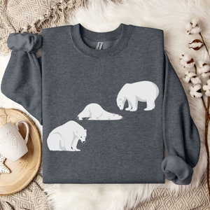 Peut inclure: Un sweat-shirt gris fonc&eacute; avec un motif blanc de trois ours polaires. Deux des ours sont couch&eacute;s et un est debout.